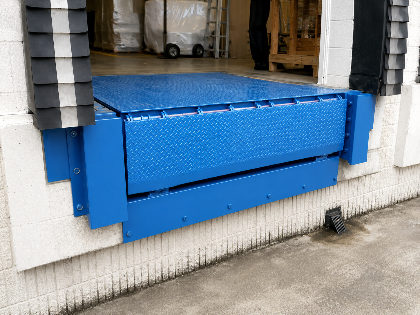 Dock leveler installed at commercial entrance — front elevation view